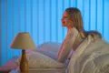 The smile girl sitting on the bed. Evening night time Photo