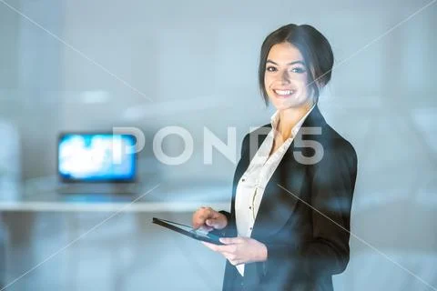 The smile lady stand with the tablet over the window Stock Photos