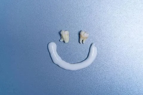 Smile made with teeth and toothpaste on blue background Stock Photos