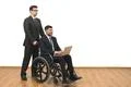 The smile man and an invalid work with a laptop on the white wall background Photo
