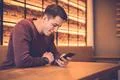 The smile man sitting with a phone at the restaurant table Photo
