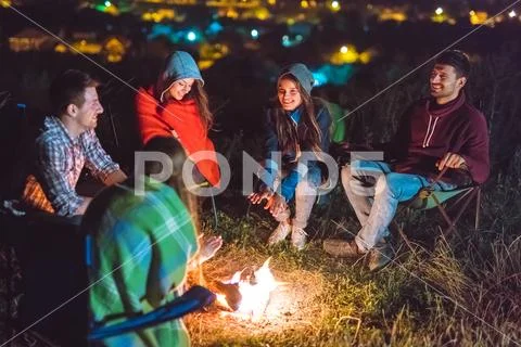 The smile people hold hands near the bonfire. night time Stock Photos