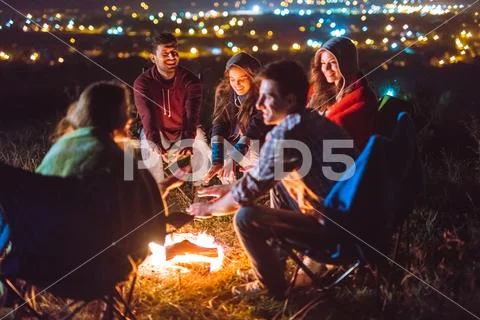 The smile people hold hands near the bonfire. night time Stock Photos