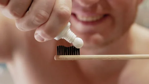 Smile squeezes toothpaste onto a toothbrush in the bathroom Stock Footage 212050057