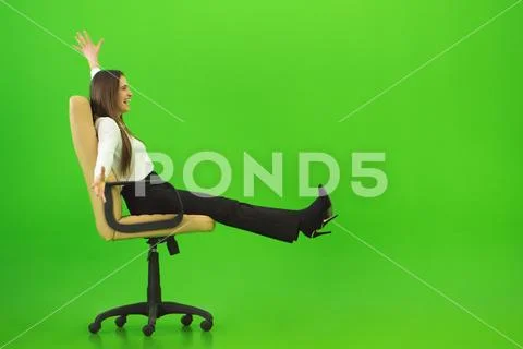 The smile woman fun on the chair on the green background Stock Photos