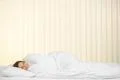 The smile woman lay on the bed on the background of a blind Photo