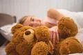 The smile woman lay on the bed with soft toy Photo