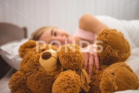 The smile woman lay on the bed with soft toy Stock Photos