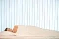 The smile woman lay in the bed with a white linens Photo