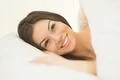 The smile woman lay in the white linens Photo