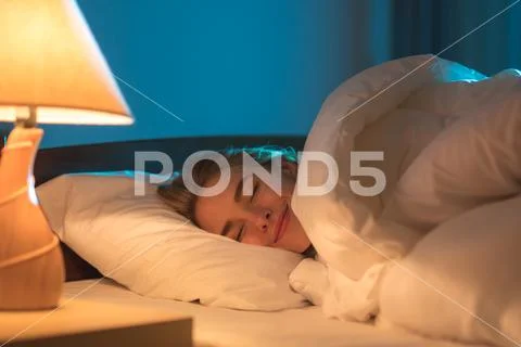 The smile woman sleeping on the bed Stock Photos