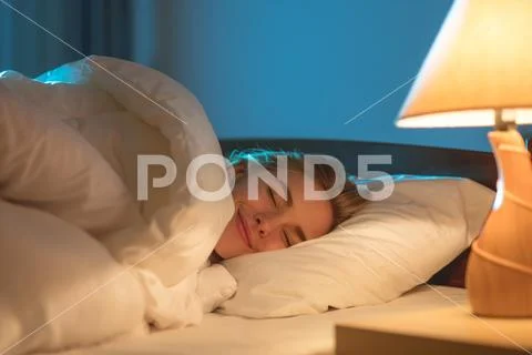 The smile woman sleeping on the bed Stock Photos