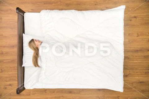 The smile woman sleeping on the bed. View from above Stock Photos