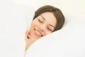 The smile woman sleeping in the white linens Photo