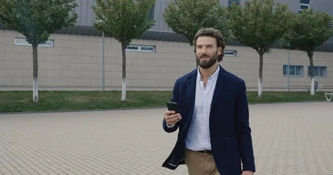 Smiled Business Man using Smartphone, walking on the Business District Streets Stock Footage 117691623