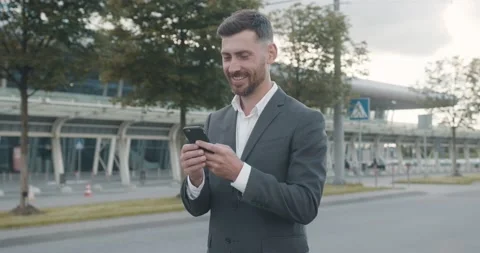 Smiled Man in Classical Suit Texting Funny Massage while walking near Airport Video stock 147051338