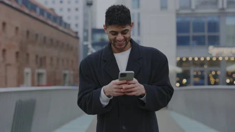 Smiled multiethnic man texting with clients walking downtown. Male is happy Stock Footage 224646334