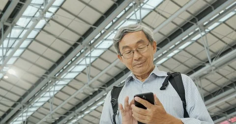 Smiled senior man using mobile phone on the flight timetable. 스톡 동영상 116663242