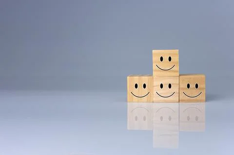 Smiles on the cube. It represents positive ratings, feedback and customer rev Stock Photos