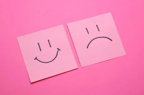 Smiley and sad face notes on pink background Stock Photos