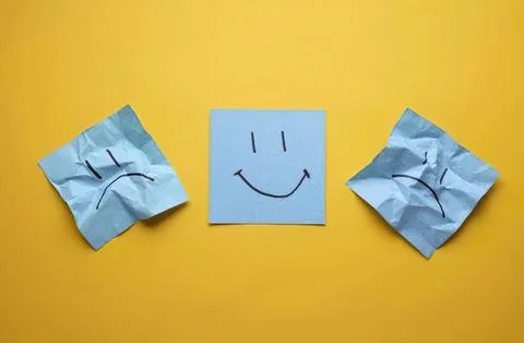 Smiley face drawing on a sticky note with sad and angry notes Stock Photos