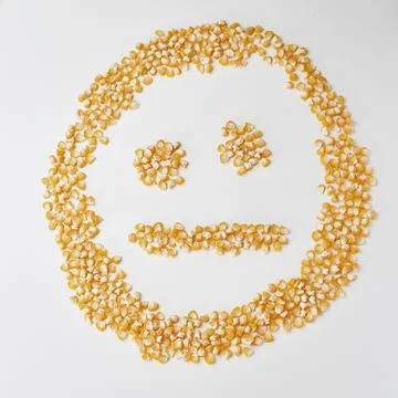 Smiley face made of corn seeds on a white background, emotion neutral Stock Photos