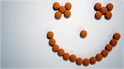 Smiley face made of orange pills on white background top view Stock Footage 337148585
