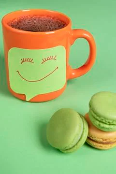 Smiley face sketch on a sticky note on a cup of coffee. Cup of coffee with a  Stock Photos