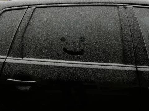 Smiley in snow on car window Stock Photos