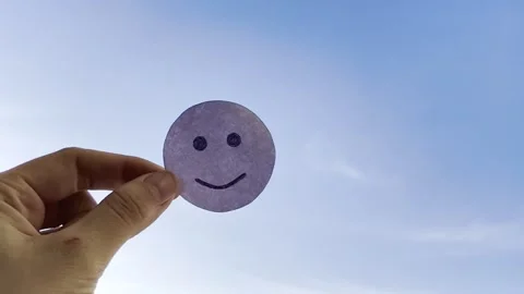 Smiley from white paper on blue sky background Video stock 262150124