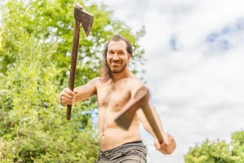 Smiley wild man with bared torso with two axes Stock Photos