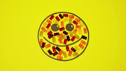 Smiley On Yellow Background Filled With Colored Candies. Stock Footage 130195333