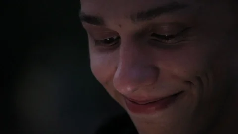 Smiley young face closeup, mobile screen light on face at darkness Stock Footage 96217310