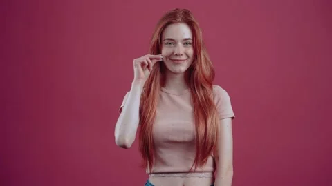 The smiling 20-year-old red-haired young woman in a pink casual T-shirt Stock Footage 150369427