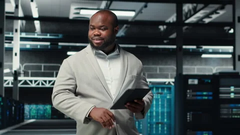 Smiling admin using tablet in in data center maintaining infrastructure Stock Footage 311833141