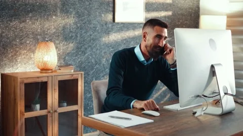 Smiling adult developer talking on smartphone in his home modern office Video stock 179628961