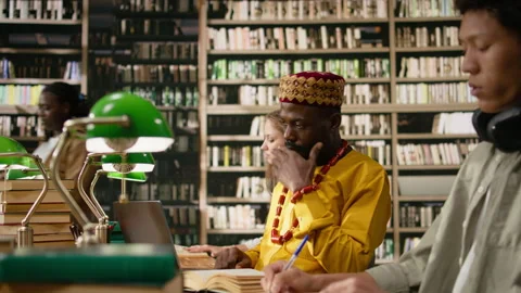 Smiling adult learner working at library table with desktop computer Stock Footage 337229152