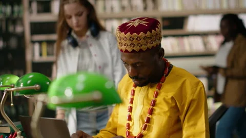 Smiling adult learner working at library table with desktop computer Stock Footage 337231483