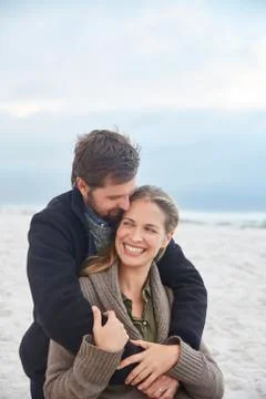 Smiling affectionate couple hugging on winter beach Stock Photos