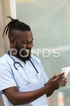 Smiling African American Doctor Holding Tablet Computer