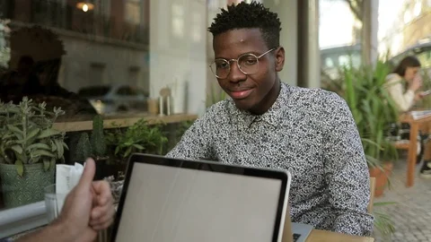 Smiling African American man using laptop in cafe Video stock 101366174