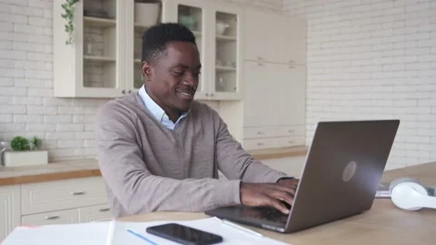 Smiling african american man using laptop computer working from home office. Stock Footage 144188157