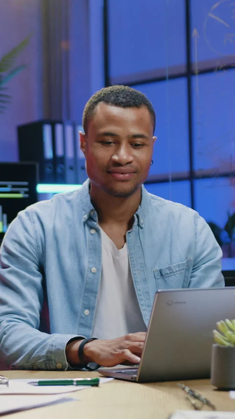 Smiling african american man worker typing on computer in modern office in the e Stock Footage 329187031