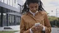 Smiling African American Woman In Headphones Using Smartphone Stock Footage
