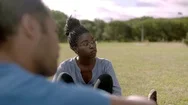 Smiling African American Woman Talking With Friends On Lawn Stock Footage