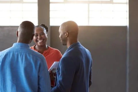 Smiling African work colleagues talking together in a modern office Stock Photos
