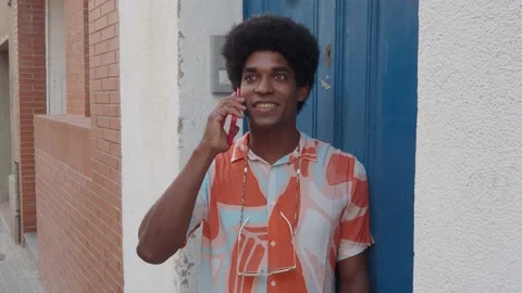 Smiling afro man talking on smartphone on the street. Stock Footage 161315906