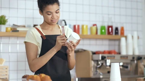 Smiling and friendly looking afro american barista holding paper cup. Stock Footage 124986536