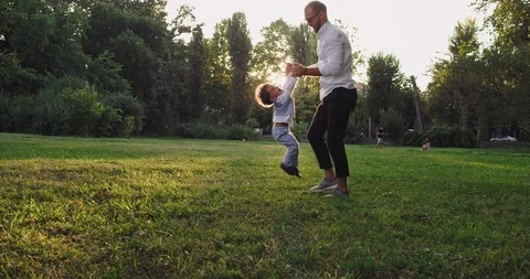 Smiling and happy dad playing lovely with his small son in the middle of the Stock Footage 117996587