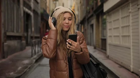 Smiling and laughing handsome young woman girl listening music from his Stock Footage 135616170